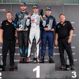 Nikodem Sobczyk (Zweiter von links), Rasmus Vendelbo (Mitte) und Bruno Görtz (Zweiter von rechts) bei der Siegerehrung der Porsche Sprint Challenge Deutschland GT4 (Foto: Porsche Sports Cup Deutschland)