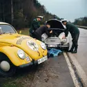 Das Titelbild des neuen ADAC Oldtimer-Ratgebers zeigt einen Gelben Engel, der havarierten Polizisten in den 1960er Jahren hilft