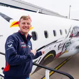 Fabio Scherer vor seinem Ford Mustang GT3 auf der Embraer E190-100LR von German Airways